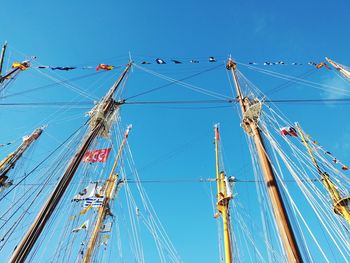 Low angle view of sailboat against clear blue sky