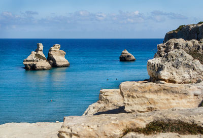 Rocks on sea shore against sky