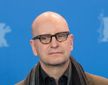 Portrait of man wearing eyeglasses against blue sky