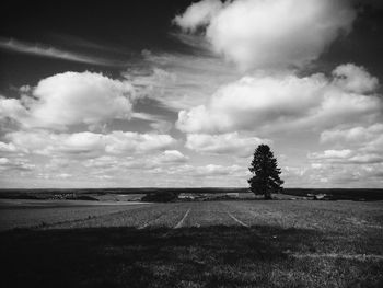 Scenic view of field against cloudy sky