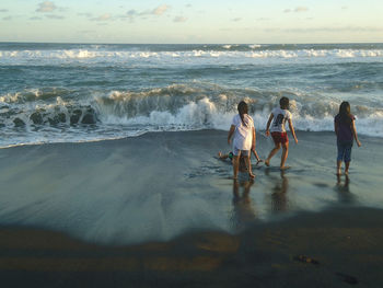 People at beach against sky