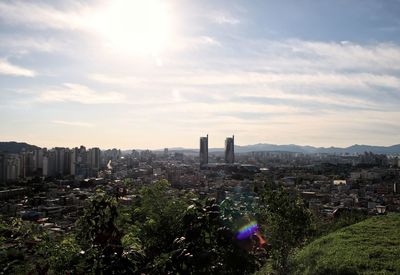 Aerial view of buildings in city against sky