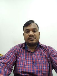 Portrait of young man standing against wall