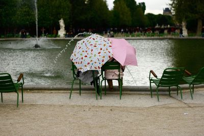 Chairs and pink umbrella on water