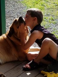 Boy with dog sitting outdoors