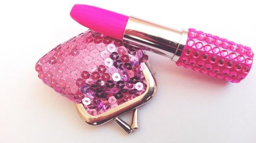 Close-up of purse and pink lipstick on table