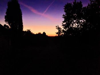 Silhouette trees against sky at sunset