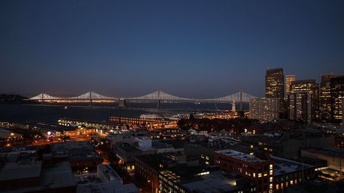 Illuminated cityscape against sky at night