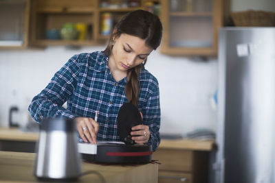 Young woman cleaning untensil at home