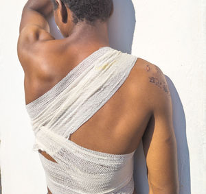 Rear view of young woman standing against white background