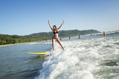 Full length of man surfing in sea against sky