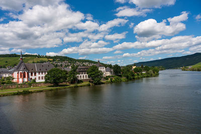 River amidst buildings in city against sky