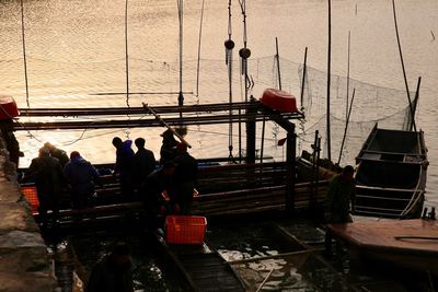 People on boat in sea against sky