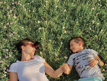 Directly above shot of mother with son lying on grassy land