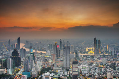 Aerial view of buildings in city during sunset