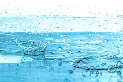 Close-up of water splashing against blue sky