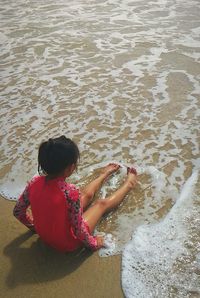 High angle view of girl sitting on beach