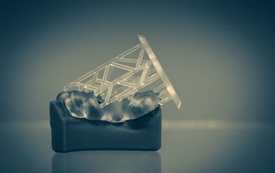 Close-up of glass container on table against blue background