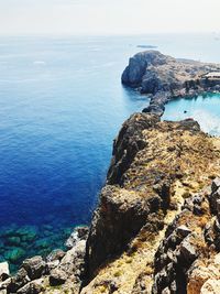 High angle view of rocks at sea shore against sky