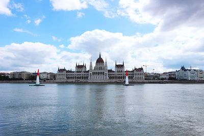 View of buildings in city against cloudy sky