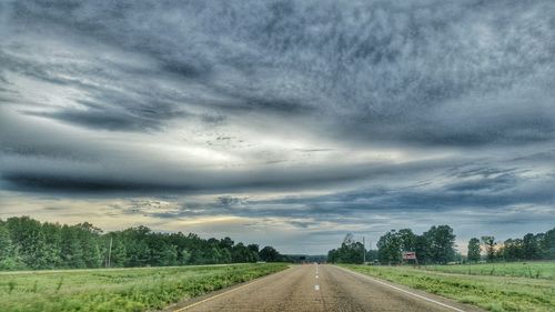 Country road against cloudy sky