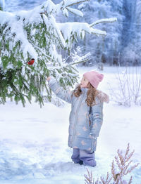 Rear view of woman standing on snow covered field