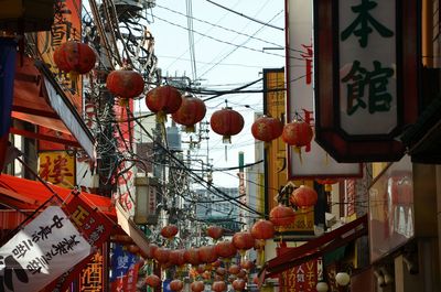 Low angle view of lanterns hanging amidst buildings in city