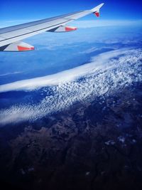 Cropped image of airplane wing over landscape