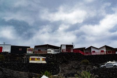 Low angle view of buildings against cloudy sky