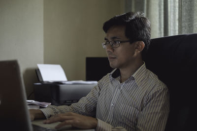 Man using laptop while sitting at office