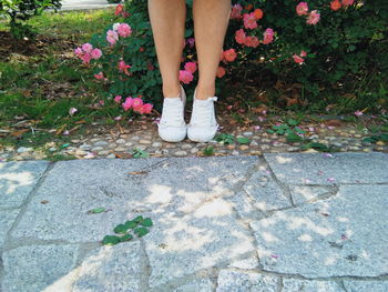 Low section of woman standing on footpath