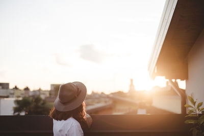 Rear view of woman looking through window