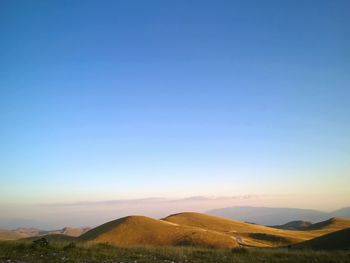 Scenic view of desert against clear blue sky