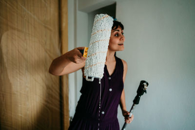 Full length of woman standing against wall