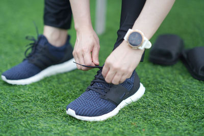 Low section of man tying shoelace