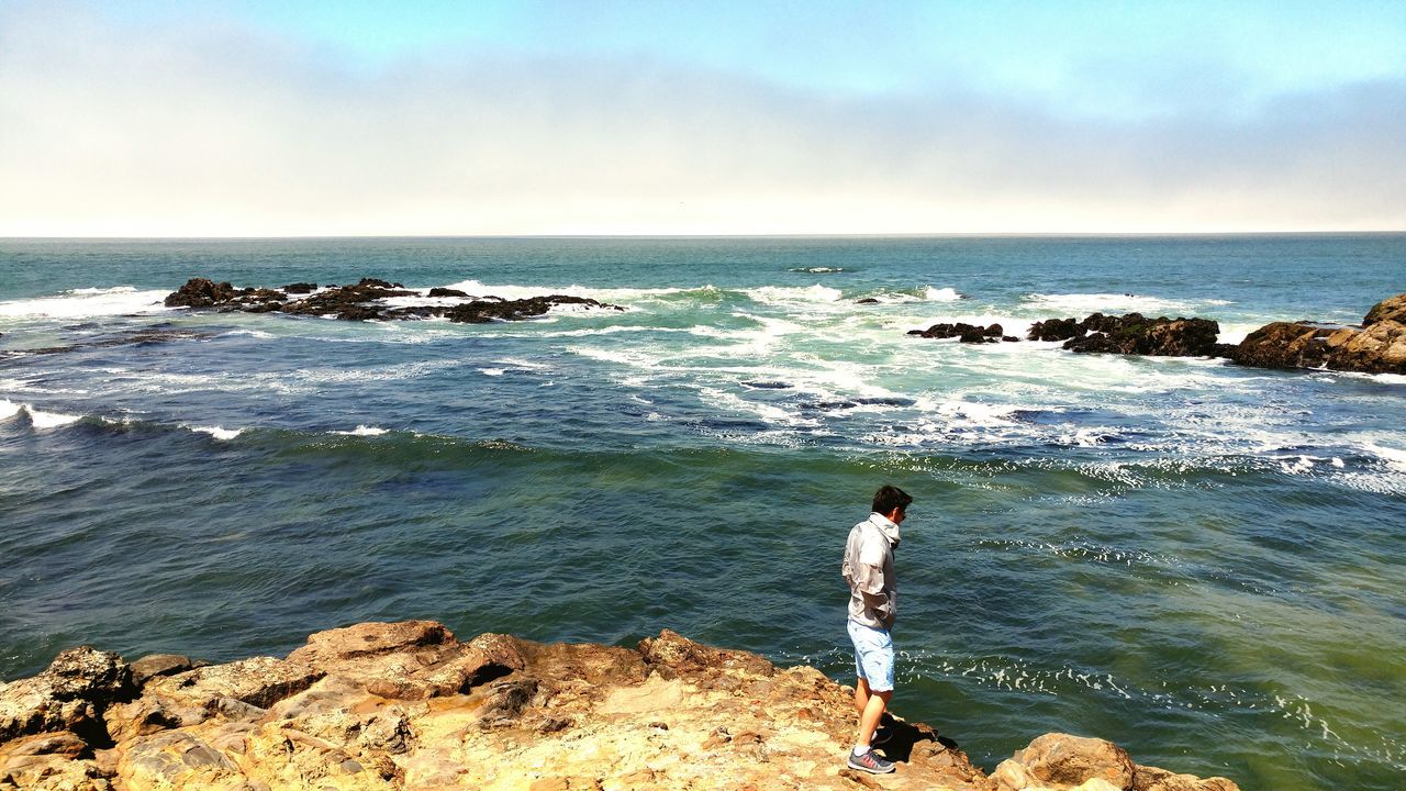 Man walking along the ocean's edge