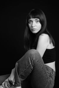 Portrait of a beautiful young woman over black background