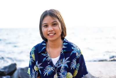 Portrait of smiling girl against sea