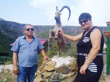 Full length of friends standing against sky