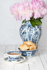 Delicate spring still life with croissants and a bouquet of pink peonies