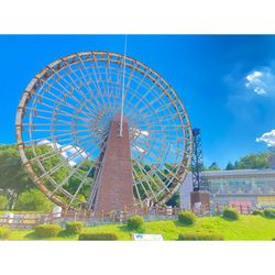 Low angle view of ferris wheel against blue sky