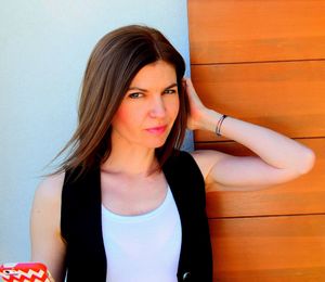 Portrait of young woman standing by wall