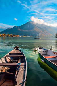 Boats moored in lake against sky