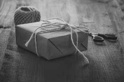 Close-up of wrapped box by scissors and twine on table