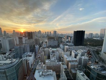 High angle view of modern buildings in city against sky during sunset