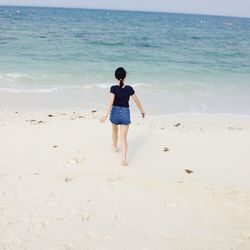 Rear view of boy standing on beach