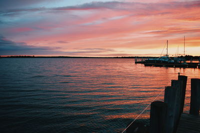 Boats moored at harbor during sunset