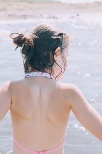 Rear view of girl against lake during sunny day