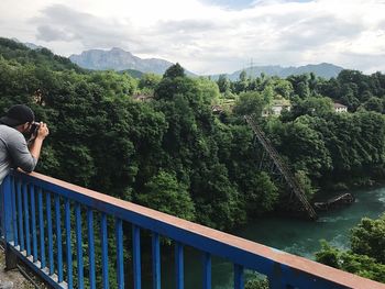 Woman by footbridge against sky