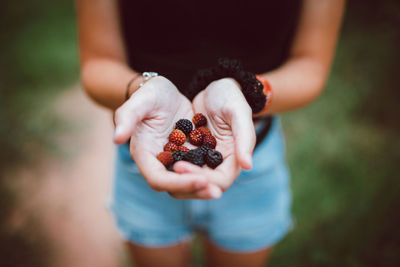 Midsection of man holding fruit